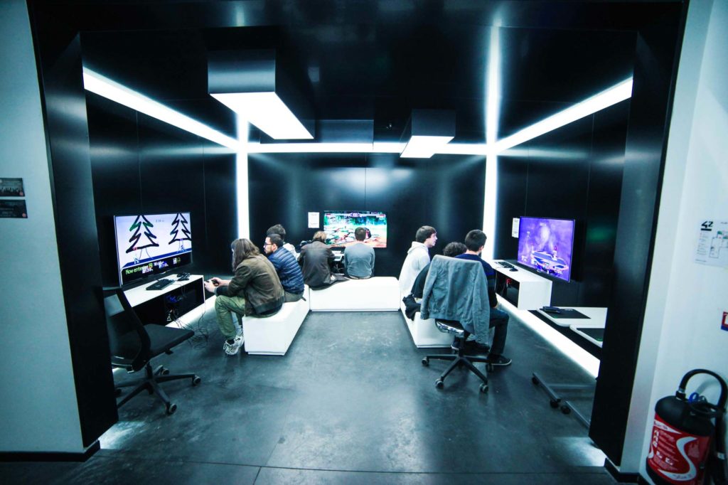 Un espace libre avec des jeux vidéo, un simulateur de réalité virtuelle et une borne d'arcade.